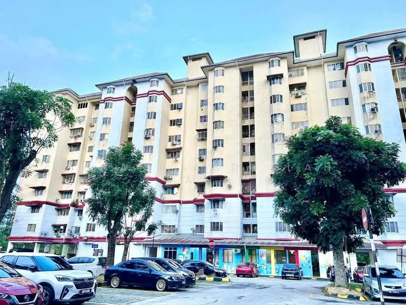 Exterior type: mid-rise condominium; features: yellow painted facade, red accent banding, balconies on upper floors, multiple windows, surrounded by trees, open-air parking lot, ground-level retail spaces, two-storey building, visible air conditioning units, street signage, manicured landscaping; style: modern.