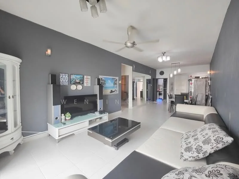 Living features: grey accent wall, white walls, white tiled flooring, 5-blade ceiling fan with light, sofa with black and white upholstery, coffee table with black surface, TV console with built-in storage, wall-mounted TV, decorative wall art, large window with natural light, recessed lighting, open layout to adjacent rooms; style: modern.