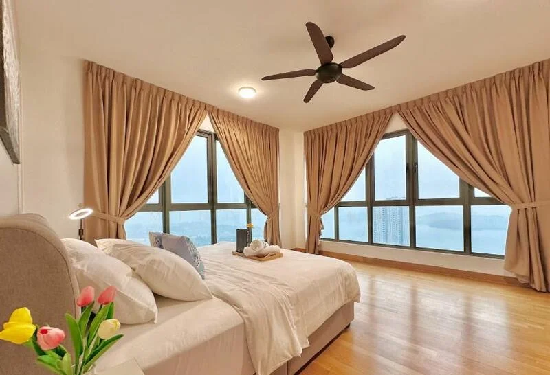 Bedroom features: king-size bed, upholstered headboard, white bedding, 2 bedside lamps, 5-blade ceiling fan, floor-to-ceiling windows, curtains in beige, wooden flooring, decorative vase with flowers, decorative pillows; style: modern; view: city.