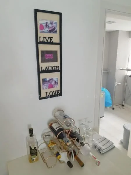 Room features: white painted walls, light wood flooring, framed wall art with text, wine rack with bottles, glassware, folded towels, visible bathroom fixtures in background; style: modern.