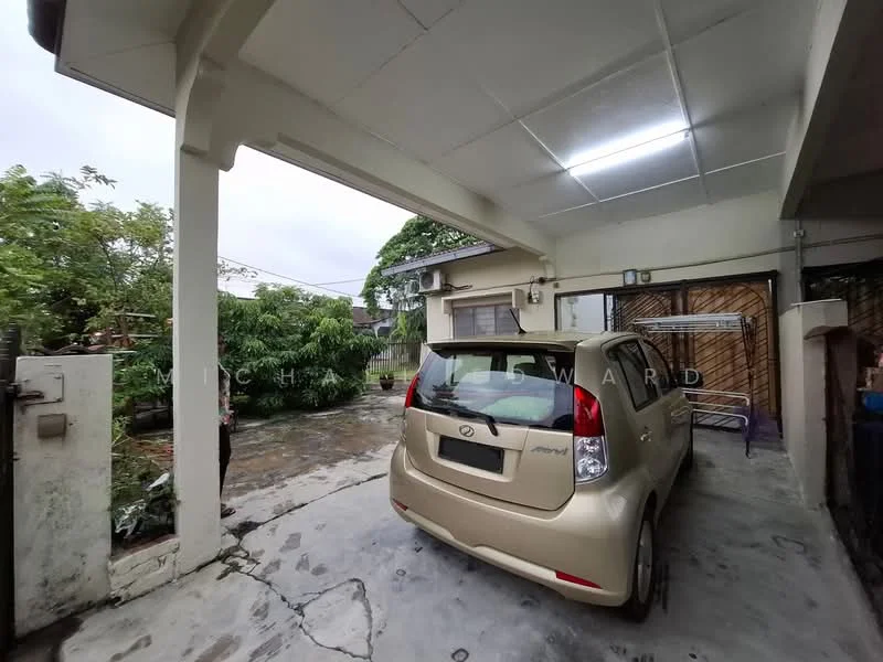 Exterior type: detached bungalow; features: car porch with awning, concrete flooring, manicured lawn, mature trees, fenced perimeter, single-storey, exposed concrete facade; style: modern.