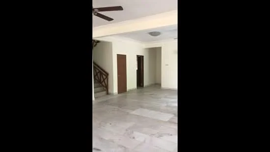 Living features: marble flooring, white painted walls, 5-blade ceiling fan, recessed ceiling lights, staircase with wooden railing, doorway leading to hallway, doorway leading to another room, open layout; style: modern.