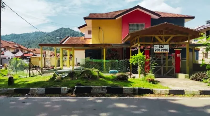 Exterior type: detached bungalow; features: two-storey building, red and yellow painted facade, pitched tile roof, front porch with wooden beams, manicured lawn, fenced yard, landscaped garden, driveway, mountain view in background; style: modern.