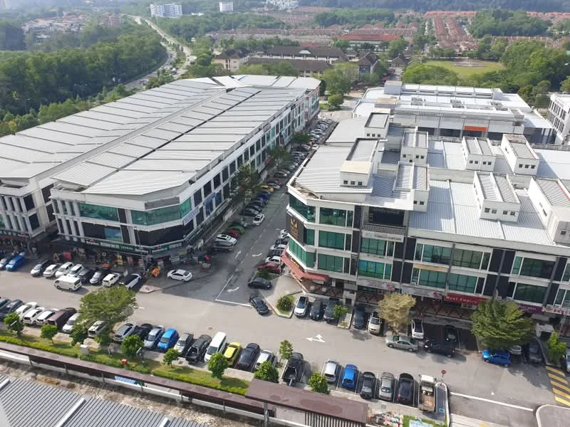 Exterior type: shophouse; features: multi-storey shophouse buildings, flat roof, glass windows, parking lot with visible cars, surrounded by greenery, urban context with nearby residential area; style: modern.