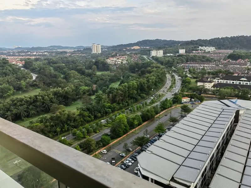Exterior type: high-rise condominium; features: city skyline view, surrounded by greenery, near main road, parking lot visible, landscaped area, hills in background; style: modern.