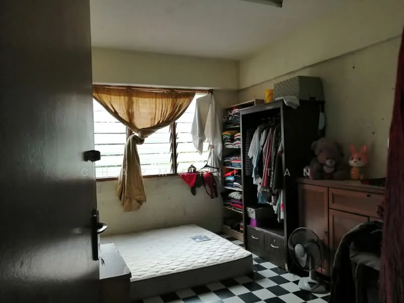 Bedroom features: checkered black and white tile flooring, white painted walls, window with sheer curtains, built-in wardrobe with sliding doors, wooden dresser, single mattress on the floor, ceiling fan, stuffed animals on the wardrobe.