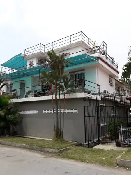 Exterior type: detached bungalow; features: white painted facade, green accent walls, flat roof with terrace, recessed balconies, metal railing on balconies, paved driveway, manicured lawn, tropical landscaping with palm trees, fenced perimeter, multiple air conditioning units visible; style: modern.