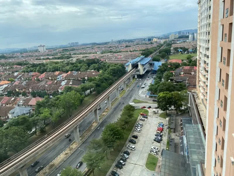 Exterior type: high-rise condominium; features: view of city skyline, nearby elevated train line, surrounded by residential areas, manicured landscaping, parking lot visible, multiple storey building, road access, greenery along the road; style: modern.