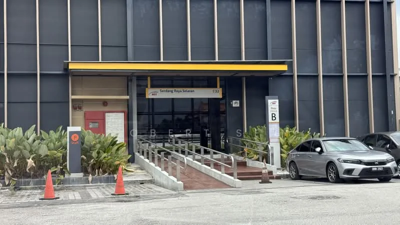 Exterior type: commercial building; features: glass facade, yellow awning, ramp access, handrails, potted plants, parking lot, marked parking spaces, entrance signage; style: modern.