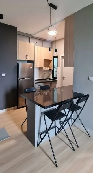 Kitchen features: black granite countertop, wood cabinetry in light finish, stainless-steel fridge, built-in oven, 4-burner gas hob, black pendant lighting, open shelving, bar seating with 2 black metal stools, light wood flooring, grey accent wall, white walls, window for natural light; style: modern.