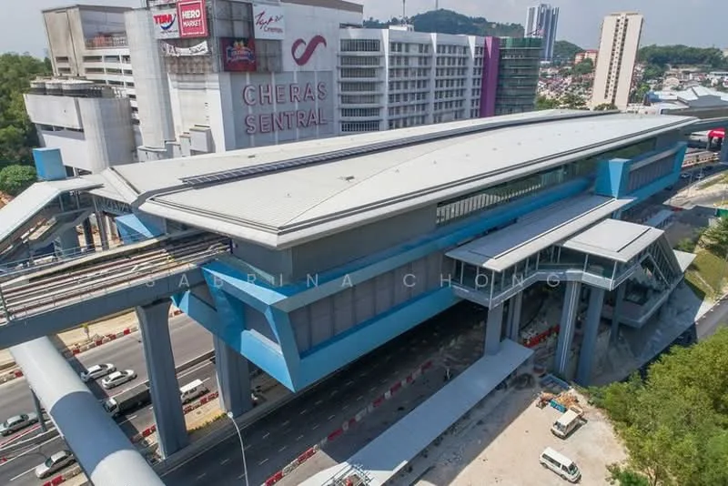 Exterior type: commercial complex; features: modern architectural design, blue painted facade, large glass windows, overhanging roof, elevated structure, surrounding road access, adjacent to public transport, multiple levels, signage on building, urban setting; style: modern.