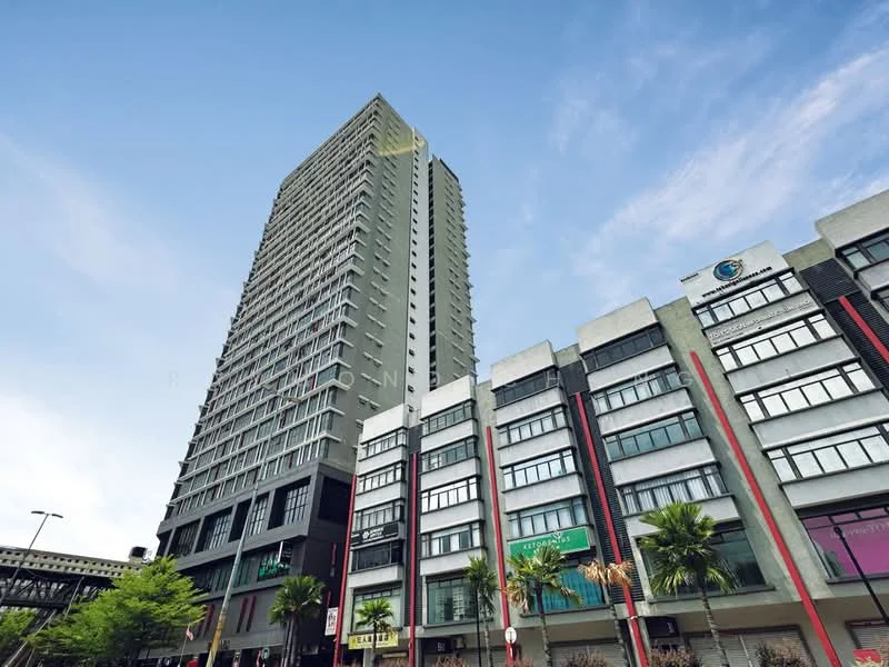 Exterior type: high-rise condominium; features: glass curtain wall, grey painted facade, recessed balconies, approximately 20-storey high-rise, surrounded by mature greenery, palm trees in landscaping, urban context with commercial units below; style: modern.