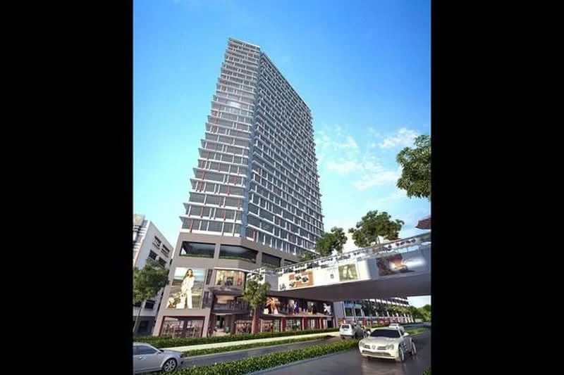 Exterior type: high-rise condominium; features: glass curtain wall, projecting balconies, multiple storeys, commercial spaces at ground level, landscaped greenery in front, surrounded by urban context, skyline view in background; style: modern.