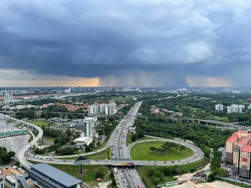 Exterior features: city skyline view, highway visible, greenery in foreground, stormy clouds, urban landscape, multiple buildings in distance; style: modern.