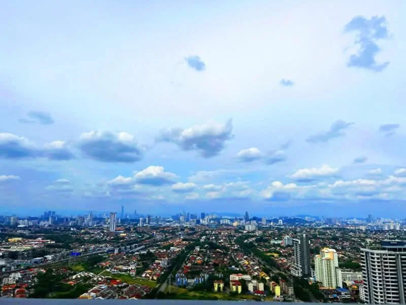 Exterior features: city skyline view, cloudy sky, urban landscape, high-rise buildings, suburban areas, green spaces, roadways, distant mountains; style: modern.
