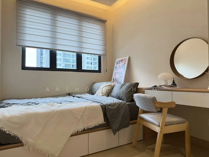 Bedroom features: queen-size bed with grey bedding, wooden bed frame, wall-mounted artwork with text, large window with roller blinds, wooden desk with drawer, upholstered chair with wooden legs, round mirror on wall, table lamp on desk, light-colored walls, recessed lighting, wooden flooring; style: modern; view: city.