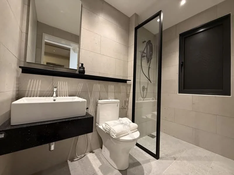Bathroom features: grey tiled walls, light grey tiled flooring, single-bowl ceramic sink, black countertop, chrome basin mixer faucet, framed mirror, one-piece toilet, walk-in shower with glass enclosure, rain shower head, handheld shower, black window with privacy screen, towels neatly arranged; style: modern.