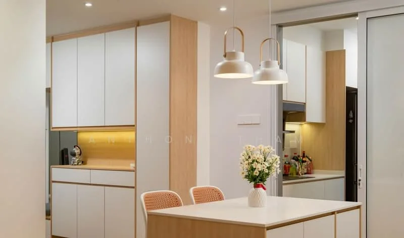 Kitchen features: white cabinetry with wood accents, marble countertop, pendant lights, built-in oven, stainless-steel fridge, kitchen island, open shelving, recessed lighting, backlit cabinetry, decorative vase with flowers; style: modern.