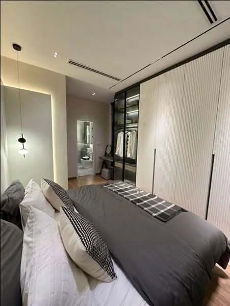 Bedroom features: king-size bed with grey bedding, black and white patterned throw pillows, built-in wardrobe with glass doors, wooden flooring, recessed downlights, pendant light fixture, neutral wall color, en-suite bathroom visible in the background; style: modern.