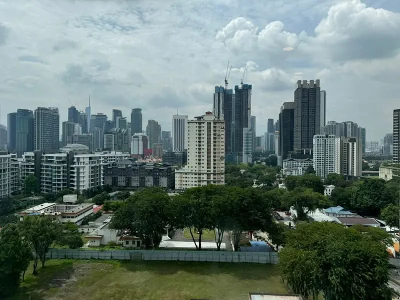 Exterior type: high-rise condominium; features: city skyline view, surrounded by mature greenery, urban landscape, multiple high-rise buildings, open green space in foreground; style: modern.
