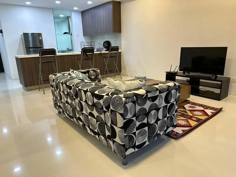Living features: 3-seater fabric sofa with geometric pattern, coffee table, TV console, wall-mounted TV, area rug with geometric pattern, polished tile flooring, recessed downlights, open-plan layout to kitchen, decorative cushions; style: modern. Kitchen features: stainless-steel fridge, wood cabinetry, countertop with bar stools, built-in stove, kitchen island, recessed lighting; style: modern.