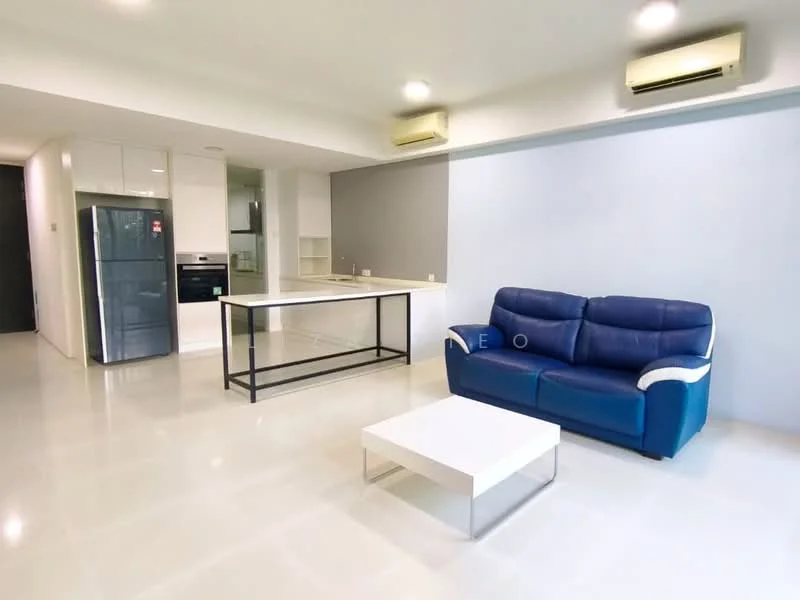 Living features: 3-seater leather sofa in blue and white, coffee table with metal legs, open-plan layout, white walls, recessed downlights, 2 wall-mounted split AC units, glossy tile flooring, kitchen area visible in background, kitchen island with bar seating, built-in cabinetry, stainless-steel fridge, built-in oven; style: modern.