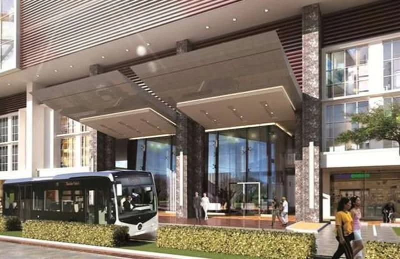 Exterior type: high-rise condominium; features: glass facade, stone cladding, recessed balconies, double-volume main lobby, feature lighting at entrance, manicured landscaping, covered entrance, visible public transport bus, outdoor seating area, large windows, modern architectural design; style: modern.