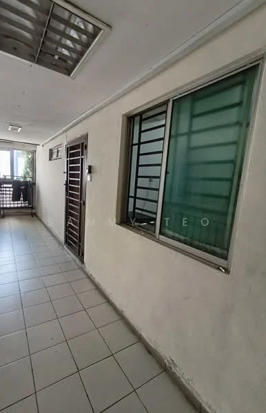 Room features: white painted walls, tile flooring, sliding window with green glass, metal security grille, ceiling light fixture, open balcony access, corner wall, interior corridor.