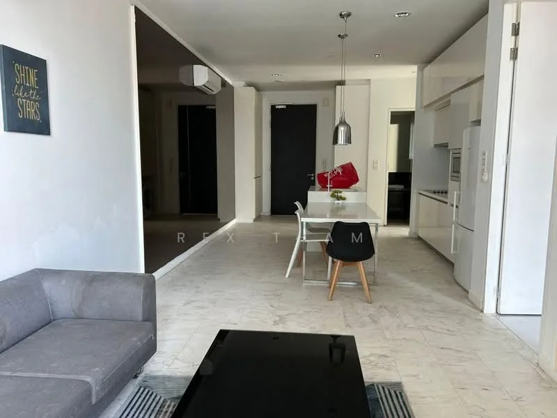 Living features: grey fabric sofa, black coffee table, area rug with geometric pattern, wall-mounted TV, recessed downlights, white painted walls, marble tile flooring, floor-to-ceiling windows, sliding glass door; style: modern. Dining features: white dining table, 4 wooden dining chairs, decorative centerpiece, pendant lamp, open layout to kitchen, white cabinetry; style: modern. Kitchen features: white cabinetry, stainless-steel fridge, built-in oven, freestanding range oven, single-bowl stainless-steel sink, chrome pull-down faucet, quartz countertop, tile backsplash; style: modern.