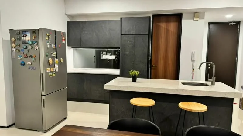 Kitchen features: grey cabinetry, white countertop, stainless-steel fridge, single-bowl stainless-steel sink, chrome pull-down faucet, black bar stools, open shelving, built-in oven, microwave, recessed lighting, tile flooring, dark accent wall, large window, decorative plant; style: modern.