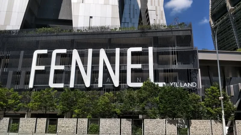 Exterior type: high-rise condominium; features: glass curtain wall, vertical fins, manicured landscaping, concrete planters, large signage, modern facade, surrounded by greenery; style: modern.