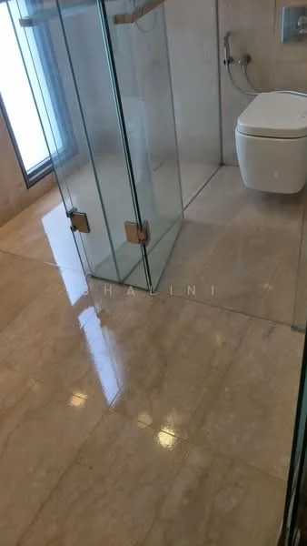 Bathroom features: glass shower enclosure, marble tile flooring, one-piece toilet, wall-mounted faucet, chrome shower head, neutral wall tiles, sliding glass door, built-in wall shelf; style: modern.