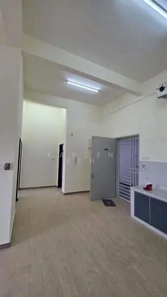 Room features: white painted walls, light wood-look flooring, fluorescent ceiling lights, grey door, window with security bars, kitchenette area with sink, open layout, high ceiling; style: modern.