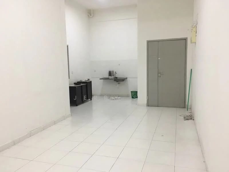 Room features: white painted walls, white tiled flooring, single door, kitchenette with sink, black cabinets, green trash bin, cleaning equipment, no visible appliances; style: minimalist.