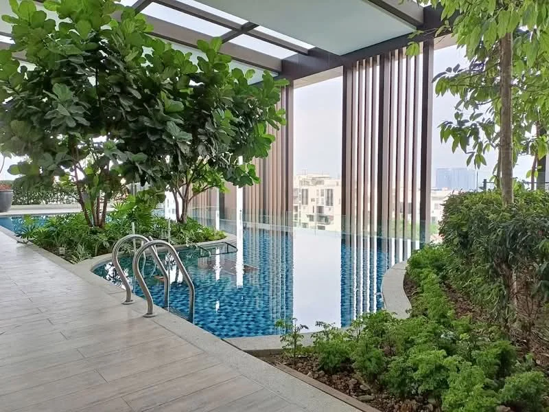 Exterior type: swimming pool deck; features: infinity pool, swimming pool with blue mosaic tiles, landscaped garden with greenery, decorative plants, wooden slatted privacy screen, poolside steps, surrounding greenery, city skyline view in background; style: modern.
