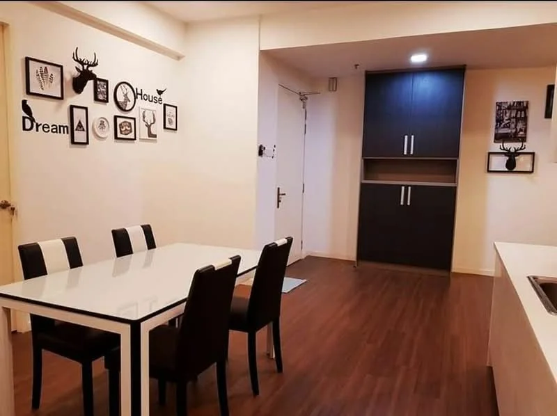 Dining features: white dining table with black trim, 4 black upholstered dining chairs, wooden flooring, cream painted walls, decorative wall art with animal motifs, wall clock, built-in cabinetry with dark wood finish, recessed ceiling lights; style: modern. Room features: white painted walls, door to hallway, light switch, flooring matching dining area.