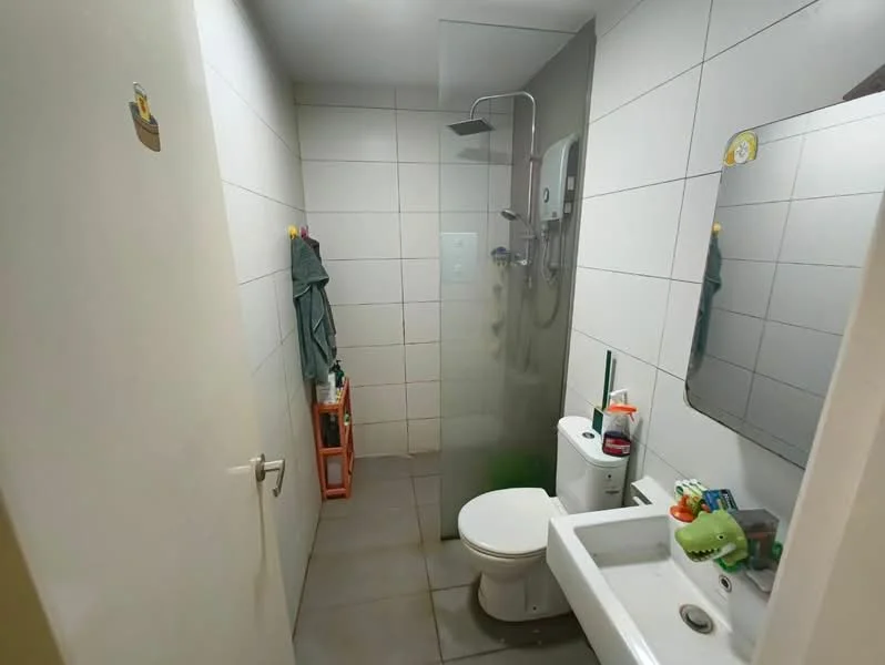 Bathroom features: white tiled walls, grey tiled flooring, walk-in shower with glass enclosure, rain shower head, chrome basin mixer faucet, single-sink vanity with white cabinet, toilet, framed mirror, shower wall with built-in shelf, toiletries on sink; style: modern.