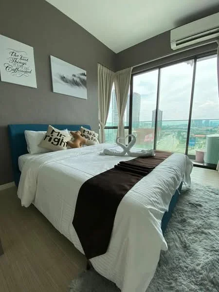 Bedroom features: king-size bed with white bedding, blue upholstered headboard, decorative throw pillows, towel swan decoration, light wood flooring, floor-to-ceiling windows, sheer curtains, air conditioning unit, wall-mounted artwork, grey accent wall, area rug with soft texture, nightstand with decorative items; style: modern; view: city.
