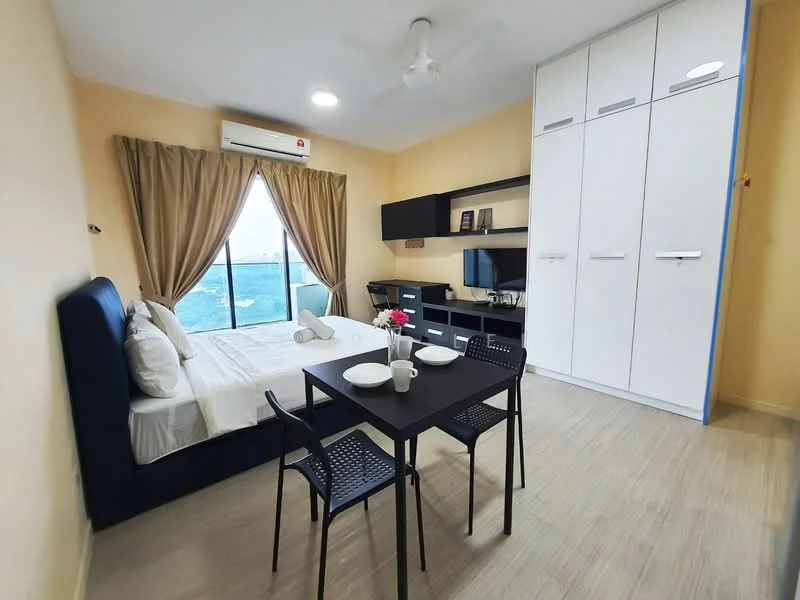 Bedroom features: queen-size bed with upholstered headboard, white bedding, 2 bedside tables, black dining table with 4 chairs, built-in wardrobe with white doors, wall-mounted TV, desk area with chair, floor-to-ceiling window, curtains, light-colored walls, wooden flooring, ceiling fan with light; style: modern; view: sea.