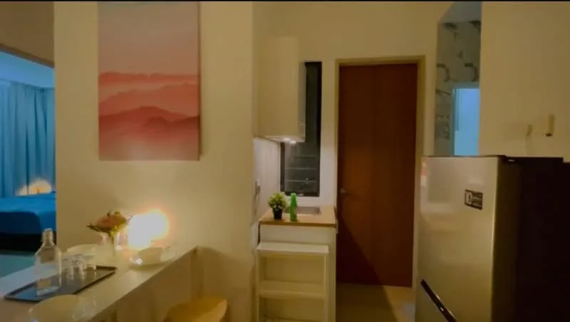 Kitchen features: white painted walls, glossy tile flooring, single-bowl stainless-steel sink, chrome pull-down faucet, white cabinetry, built-in countertop, stainless-steel fridge, decorative wall art, table with seating, small potted plant; style: modern.
