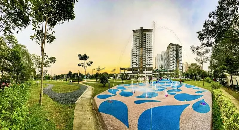 Exterior type: high-rise condominium; features: two high-rise buildings, water fountain feature, play area with colorful flooring, manicured lawn, trees and greenery, walking path, open space, sunset sky, surrounding landscaping; style: modern.