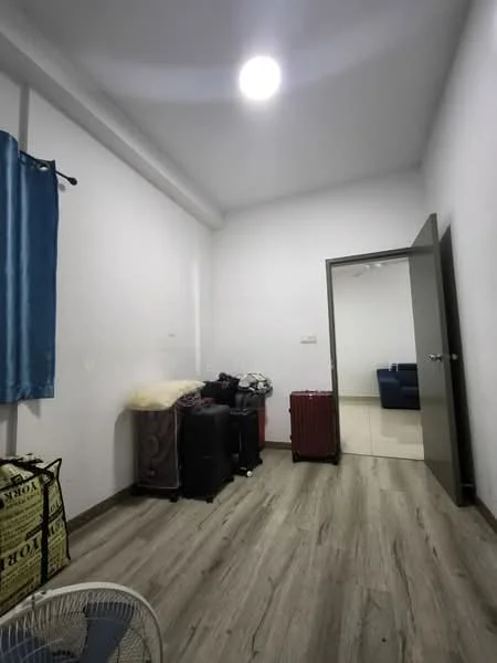 Room features: white painted walls, laminate flooring, ceiling light, blue curtains, two suitcases, one black bag, one red suitcase, fan, door leading to another room.