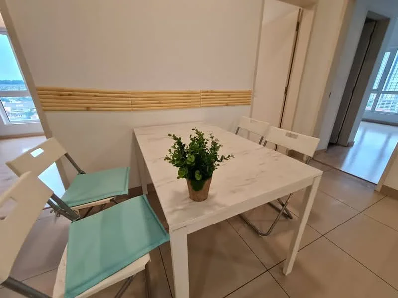 Dining features: white marble dining table, 4 white folding chairs, light blue chair cushions, decorative potted plant on table, cream painted walls, tile flooring, wooden wall paneling, large window with city view; style: modern; view: city.