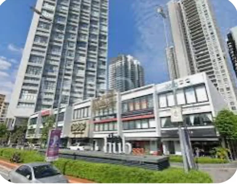 Exterior type: high-rise condominium; features: glass curtain wall, multiple storeys, prominent signage, landscaped green area, urban street view, surrounded by other high-rise buildings; style: modern.