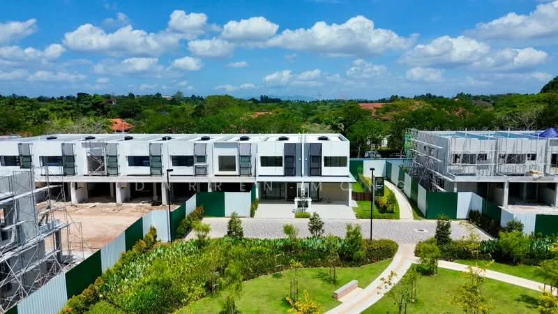 Exterior type: linked terrace house; features: white painted facade, flat roof, approximately 2-storey, manicured lawn, tropical landscaping, stone-paved walkway, scaffolding on some buildings, surrounded by greenery, open space in front, parking area, garden area; style: modern.