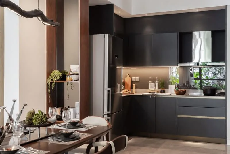 Kitchen features: black cabinetry with gold handles, stainless-steel fridge, built-in oven, induction cooktop, white quartz countertop, undermount sink, chrome pull-down faucet, recessed LED downlights, open shelving, decorative plants, wooden dining table, dining chairs with upholstered seats, table setting with plates and glasses; style: modern; view: garden.