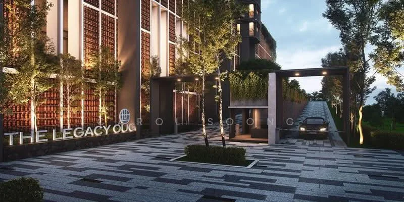 Exterior type: high-rise condominium; features: modern facade with glass and concrete, landscaped entrance with trees, paved driveway with interlocking pavers, security gate at entrance, signage with 'THE LEGACY', manicured shrubs, lighting fixtures along the pathway, car parking area, surrounding greenery; style: modern.