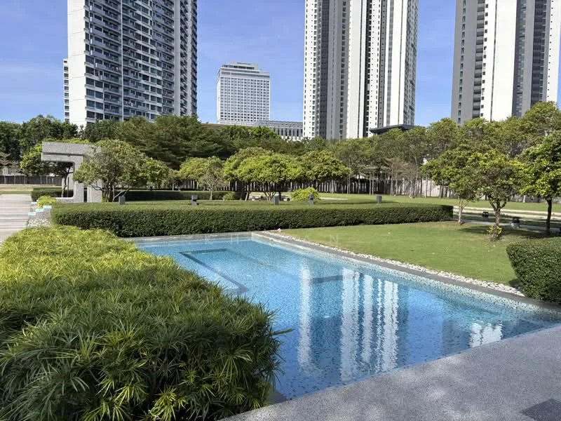 Exterior type: landscape garden; features: infinity pool, manicured lawn, mature trees, stone-paved walkway, surrounded by greenery, high-rise buildings in background; style: modern.