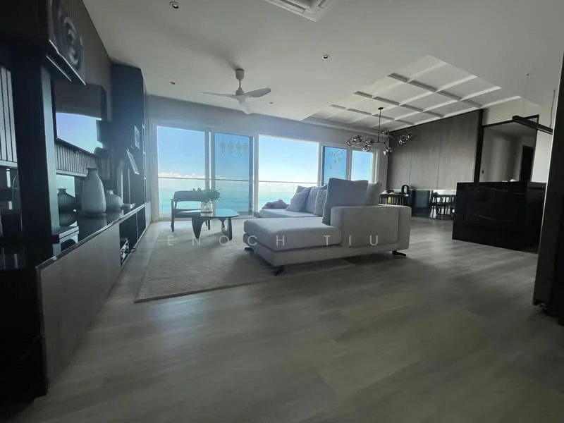 Living features: large sectional sofa in light color, area rug, coffee table, TV console, wall-mounted TV, floor-to-ceiling windows, ocean view, recessed ceiling with lighting, ceiling fan, laminate flooring in light grey, decorative wall paneling, dining area visible in background; style: modern; view: sea.