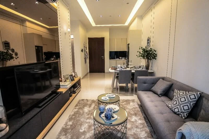 Living features: grey fabric sofa, coffee table with metallic base, area rug with plush texture, wall-mounted TV, TV console with storage, decorative wall art, recessed ceiling lights, crown moulding, floor-to-ceiling windows, dining area with table and chairs, decorative plants; style: modern.